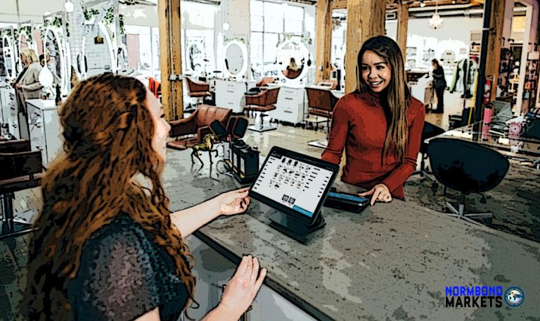woman customer at checkout paying with credit card to tablet equipped cashier 